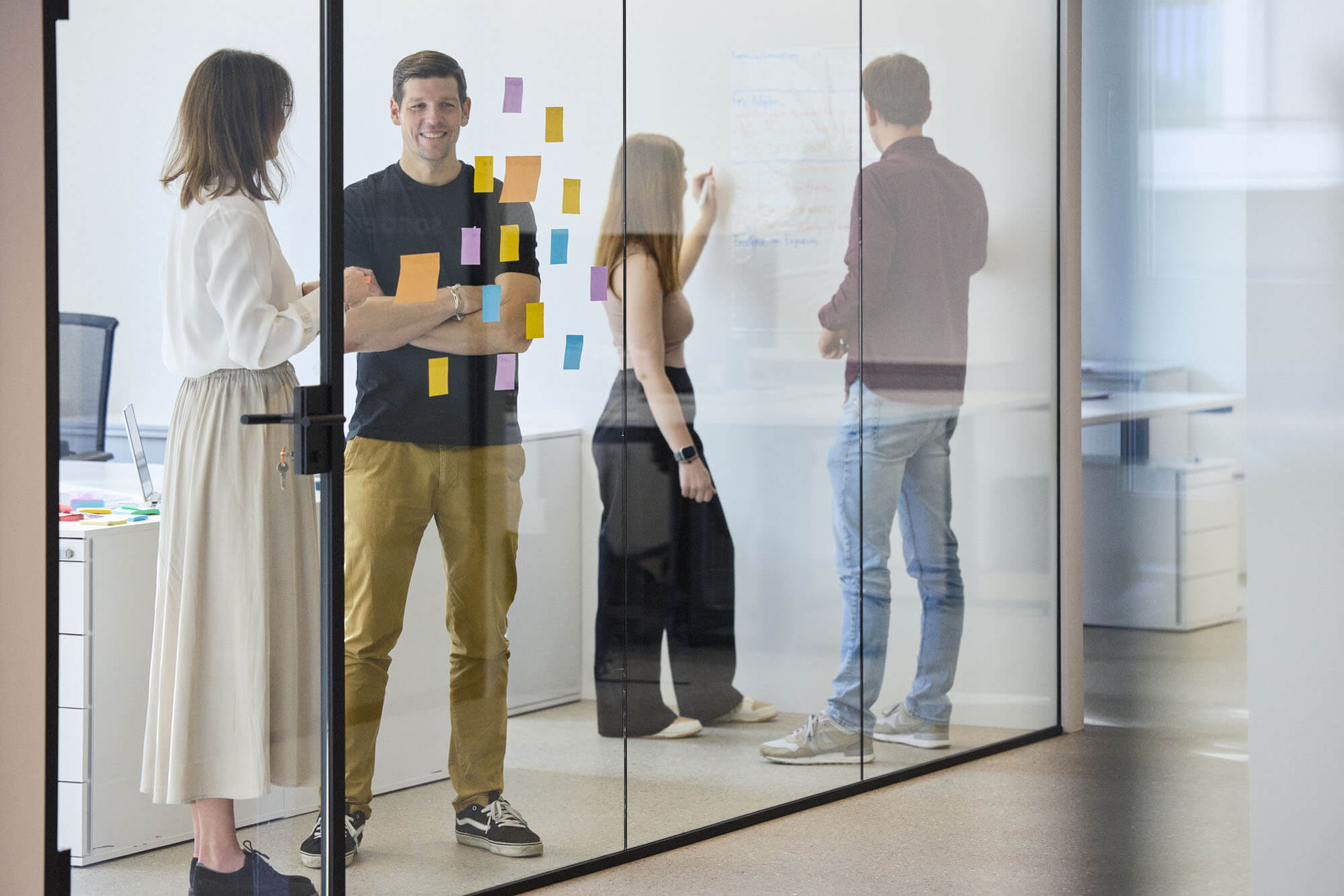 willers team im meeting raum konzipiert ein projekt und klebt notizen an die wand